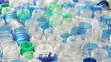 Large collection of empty plastic bottle necks in blue, green, and clear colors.